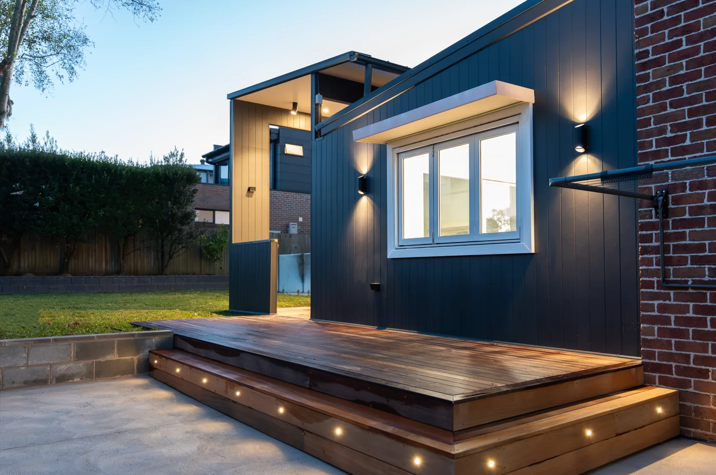 Two storey Sydney home extension photographed at dusk with lit interiors