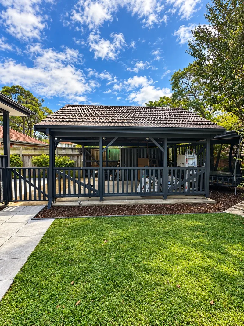 Rear view of the repainted carport with new balustrade and slat panels overlooking the lawn at Oatley